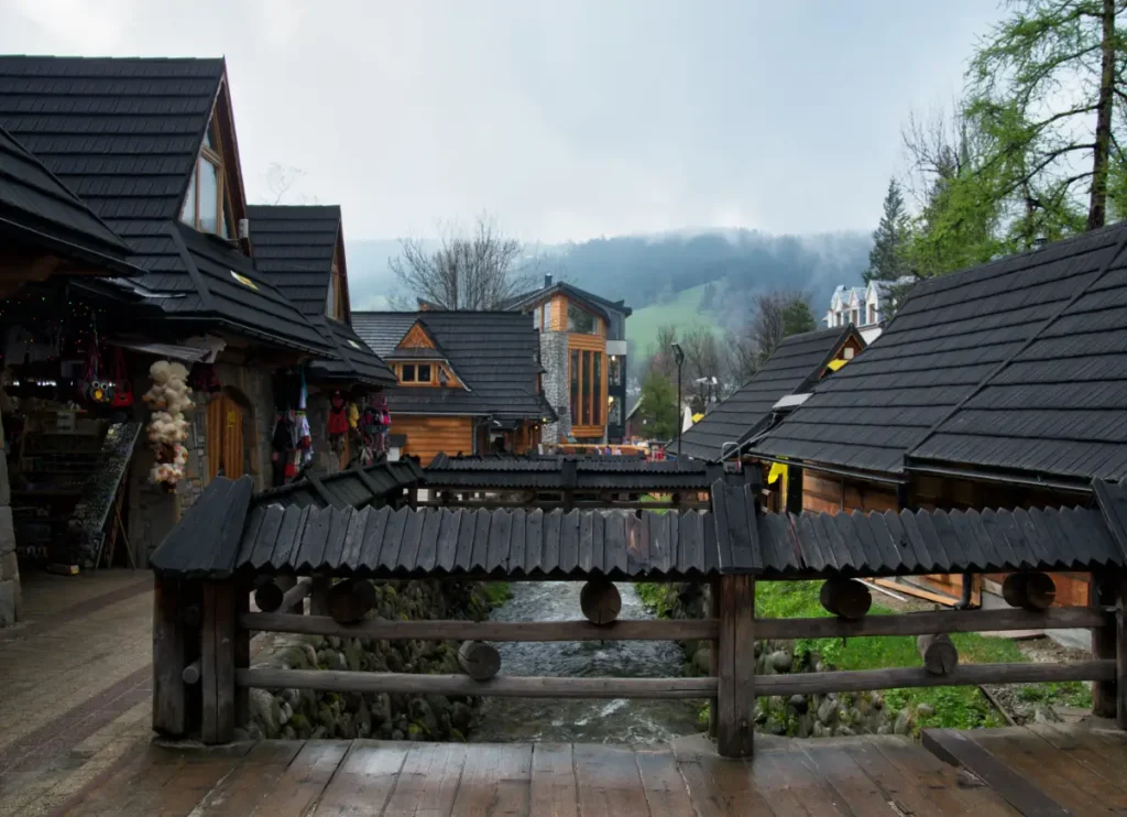 Krupówki w Zakopanem w deszczowy dzień koło Góralskich sukiennic blisko Gmachu głównego muzeum Tatrzańskiego